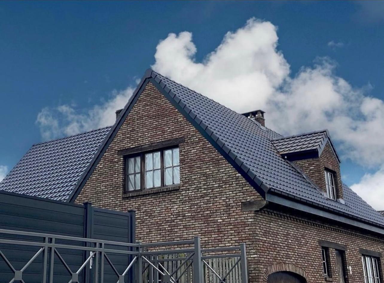 Vernieuwd hellend dak met donkere dakpannen op een karaktervolle woning in Vlaams-Brabant
